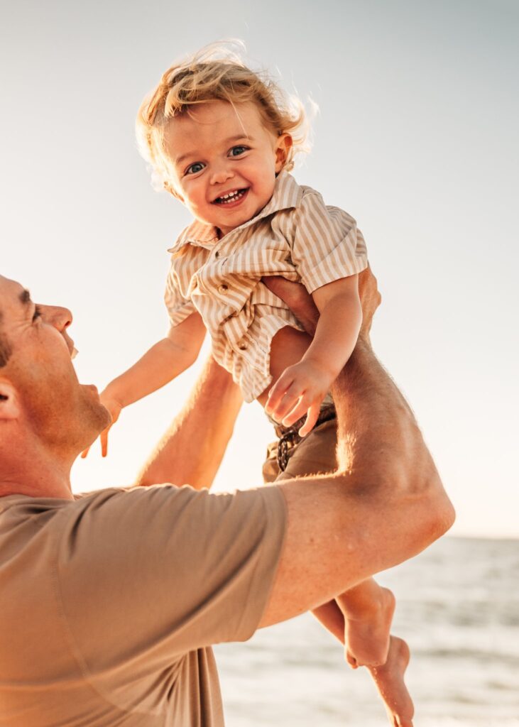 Toddler-boy-laughing-while-dad-holds-him-in-the-air