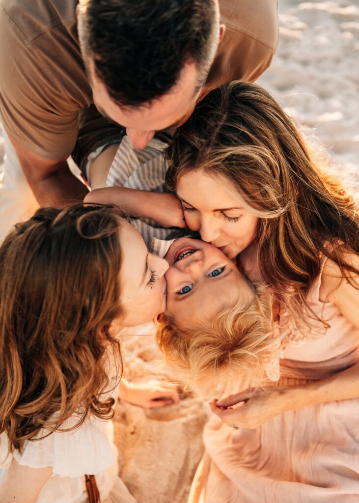 Family-kissing-baby-laughing-during-family-photoshoot
