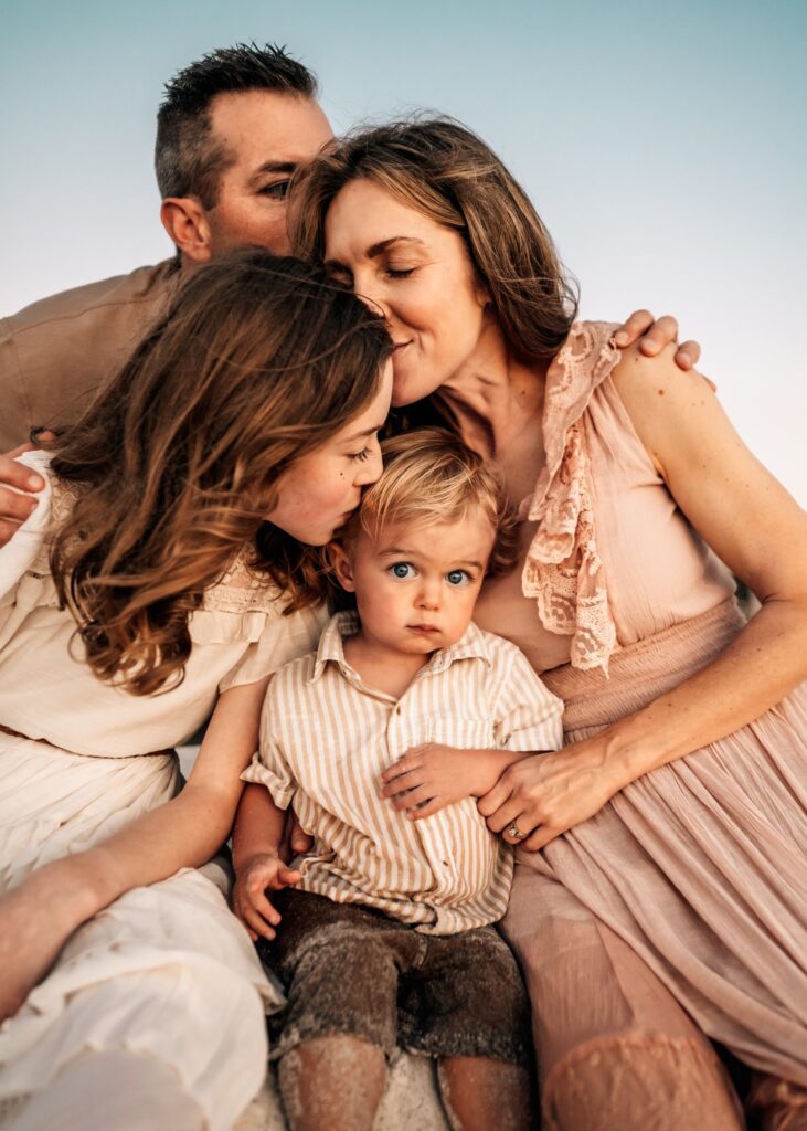 Family-kissing-baby-laughing-during-family-photoshoot