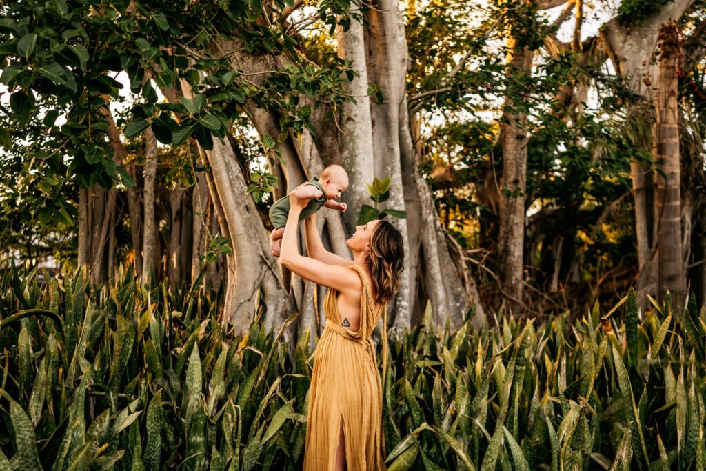 mom-holding-baby-in-air-smiling-during-photoshoot-with-florida-potographer