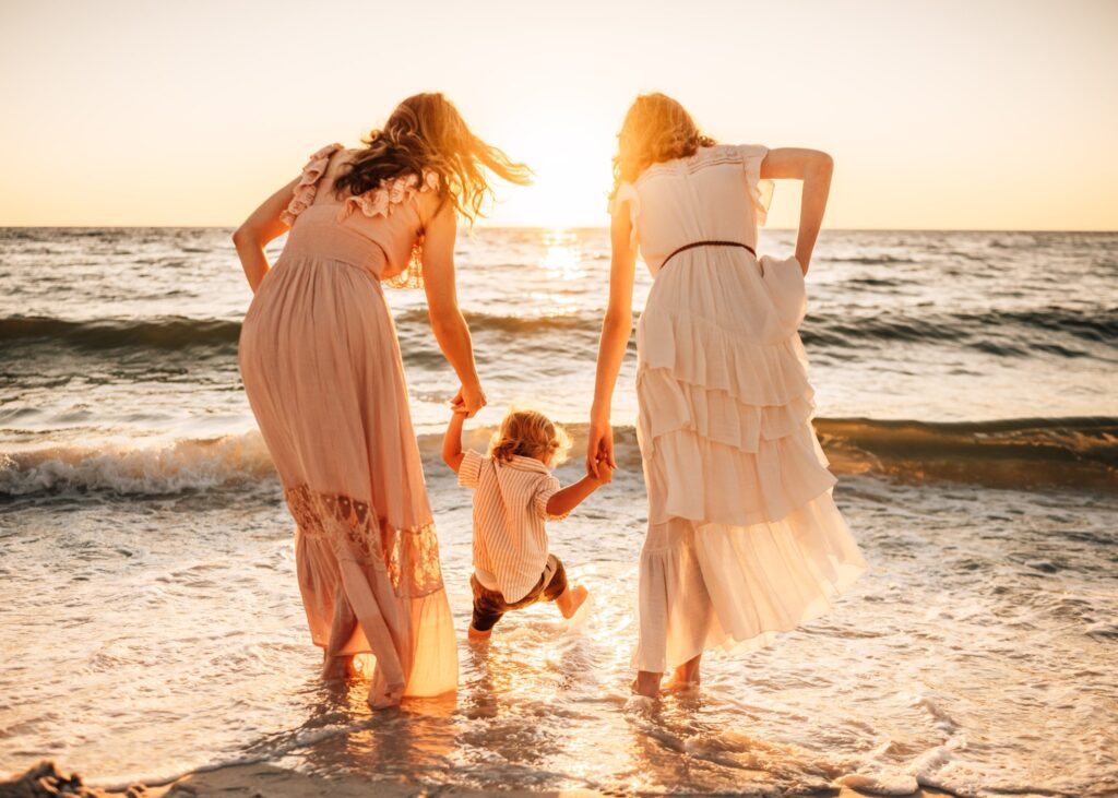 family-holding-hands-looking-at-sunset-on-the-beach-in-cape-coral-florida